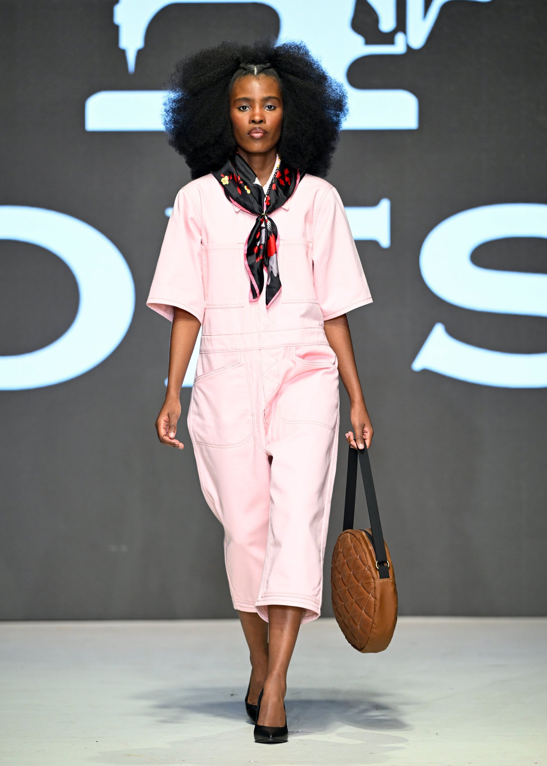 Woman on runway wearing pink overalls